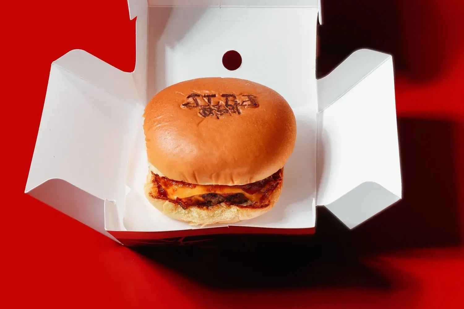 A5 Japanese wagyu patty in a brioche bun held in gloved hands, Alba Street Dubai Mall