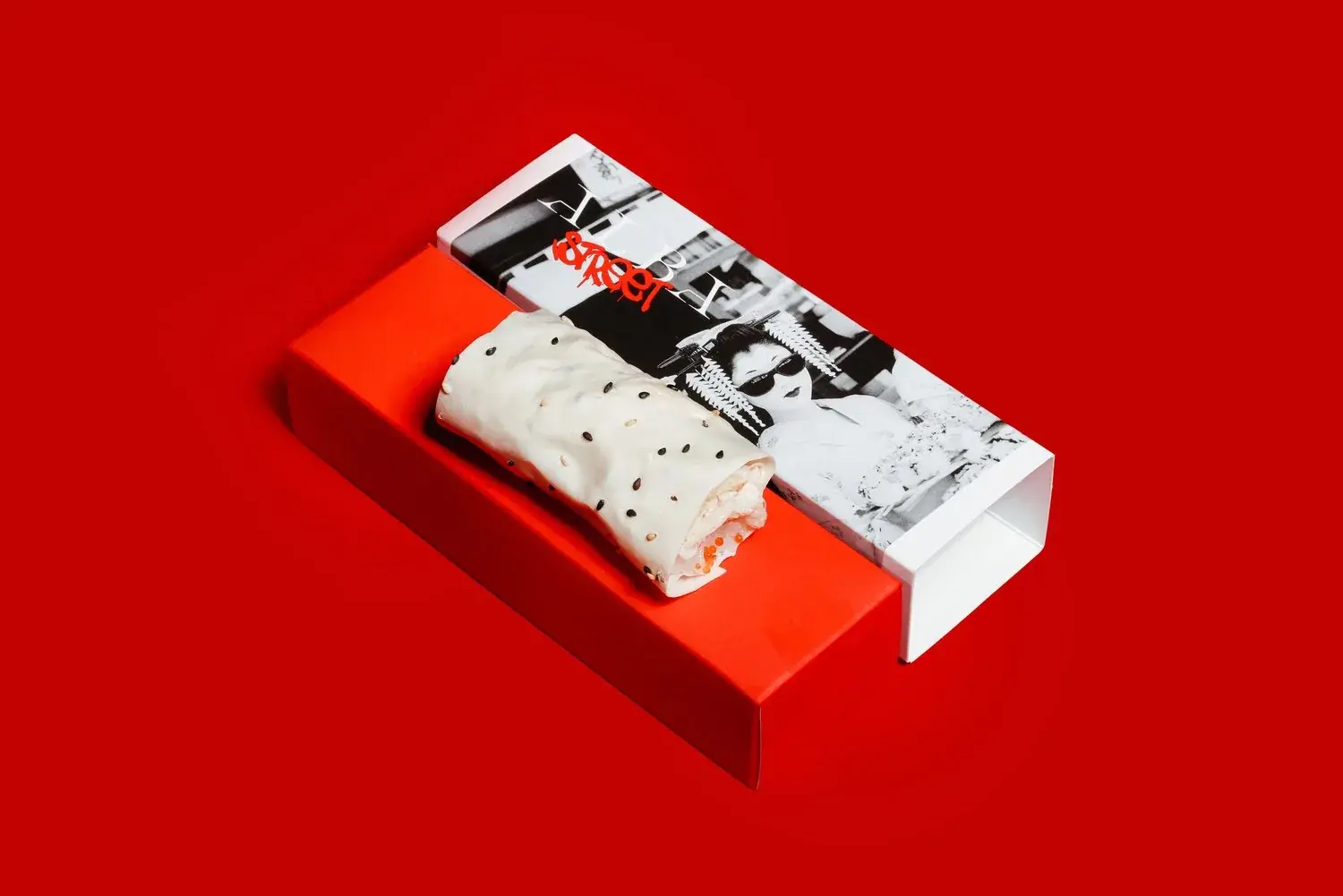 The King Crab Handroll in an Alba Street box, held in black gloved hands under a hard red key light — Alba Street, Dubai